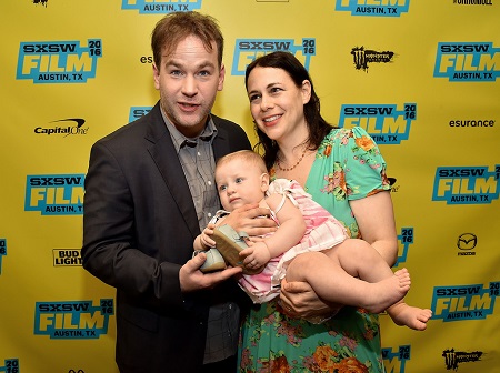 Mike posing with his baby daughter and spouse Jen
